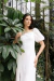 Modelo vestindo o Vestido Lille Branco em um ambiente com plantas.