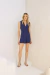 Modelo vestindo o Short Teresa Azul Marinho, peça de alfaiataria elegante, com botões frontais e cinto, em ambiente claro.