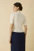 Modelo vestindo Tricot Celine Off White, blusa de manga curta, vista de costas.