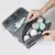 Necessaire portátil impermeável em polyester com produtos de higiene e cosméticos organizados.