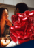 Um casal apaixonado em um jantar romântico, com balões em forma de coração vermelho ao fundo.