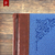 Detalle de una cubierta de cuaderno con diseño en cuero marrón y tela azul, adornada con un patrón decorativo.