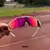 Óculos de sol esportivo Radar EV com armação branca na cor Tanzanite, com lente espelhada em tons de rosa e preto, acompanhado de uma case de proteção.