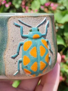 Caneca besouro verde-água e laranja na internet