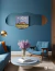 Espejo ARD Glanz Cloud de 120 x 55 cm en una sala con paredes azul y decoración moderna.