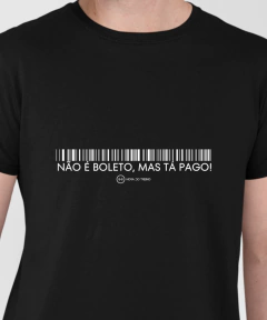 Camiseta preta com a frase "NÃO É BOLETO, MAS TÁ PAGO!" e um código de barras.