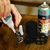 Uma pessoa aplicando cola acianocrilato em um pedaço de madeira, com um ativador em spray da marca Akfix ao fundo.