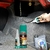 Imagem mostrando o Kit Cola Acianocrilato 125g e Ativador 400ml da Akfix em um ambiente de trabalho, com uma pessoa aplicando a cola.