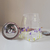 Bule transparente quadrado com pintura manual de flores de lavanda, mostrando o infusor de aço inox ao lado.