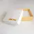 Caixa de presente branca com detalhes em amarelo, ideal para joias como o colar coração cravejado de zircônia.