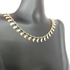 Colar choker feminino com pingentes pequenos em formato de luas douradas exibido em busto preto