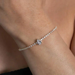 Pulseira regulável cravejada com cristais brilhantes em tom prateado, usada no pulso de uma pessoa