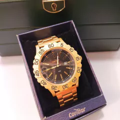 Descubra o Relógio Condor Masculino Dourado, com visor preto, resistência à água de 50M e 1 ano de garantia. Adquira já o seu e exiba estilo!
