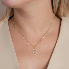 Colar Árvore da Vida cravejado de zircônias, com corrente dourada e detalhes brilhantes, adornando o pescoço de uma mulher.