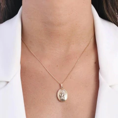 Colar relitário LCLT-1643 em destaque, usado por uma mulher com camisa branca.