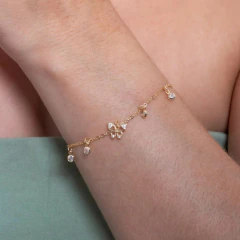 Pulseira borboleta cravejada de zircônias, delicadamente adornada, em um pulso feminino.