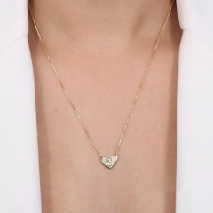 Escapulário em formato de coração com a imagem de Nossa Senhora do Carmo, pendurado no pescoço de uma pessoa.