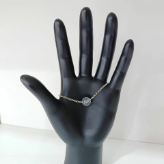 Pulseira Medalha AME em Prata 925 exibida em uma mão de manequim.