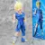 Estátua do personagem Majin Vegeta, com cabelos loiros e roupas rasgadas, em pé sobre uma superfície cinza.