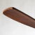 Detalle de la hélice de un ventilador de diseño elegante en color madera oscura.