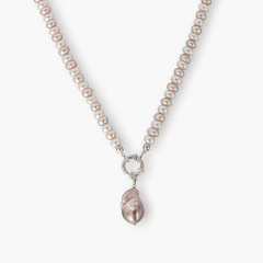 Colar Boreal branco com pérolas naturais e pingente de pérola em formato irregular usado por mulher com blusa marrom