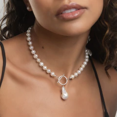 Colar Maldivas com pérolas brancas e detalhe em gota, usado por uma modelo.