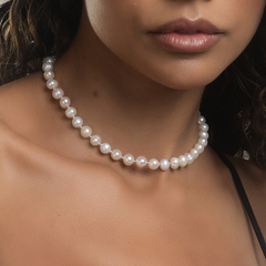 Colar de pérolas brancas usado por uma mulher, destacando a elegância e o estilo do acessório.