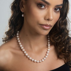 Colar Miraje de pérolas, usado por uma mulher com cabelo cacheado e maquiagem suave, destacando a elegância do acessório.