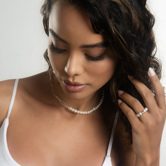 Modelo usando colar de pérolas com detalhes em metal e brincos combinando, destacando a elegância do acessório.