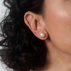 Brinco Moon Rose em uma orelha, destacando uma pérola elegante e discreta.