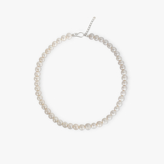 Gargantilha de pérolas clássica adornando o pescoço de uma mulher.