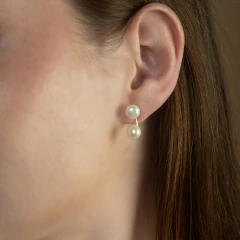 Brinco Gemini M com pérolas duplas usado na orelha de mulher
