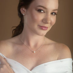 Mulher usando colar delicado com pingente de gota de luz em formato de pérola e brinco combinando