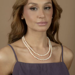 Colar orla dourada com pérolas naturais exibido em caixa de presente preta com borda bege