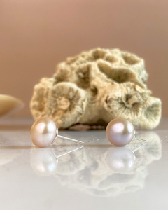 Brinco Moon Rose com pérolas em fundo suave e textura de coral