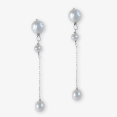 Brinco Breton com pérolas brancas e correntes prateadas, estilo elegante e moderno.