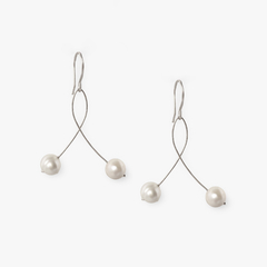 Brinco infinito com design elegante, apresentando duas pérolas em fios metálicos.