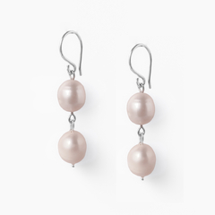 Brinco com duas pérolas rosadas penduradas em gancho prateado.