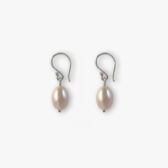 Brinco Paros pêssego com pérolas em tom suave, pendurado com fecho prateado.