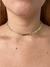 Choker dourado em destaque, ajustado ao pescoço, mostrando detalhes de design.