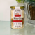 Frasco de risotto artesanal "Risotto Per Festeggiare" com sabor de maçã e castanhas, contendo 250g. Rótulo destaca características como sem glúten, sem lactose e vegano.