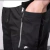 Calça preta com zíper lateral da Nike, destacando o bolso e o logotipo da marca.