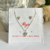 Set de joyería que incluye aretes en forma de corazón y un collar con un colgante de corazón, presentado en un empaque blanco.