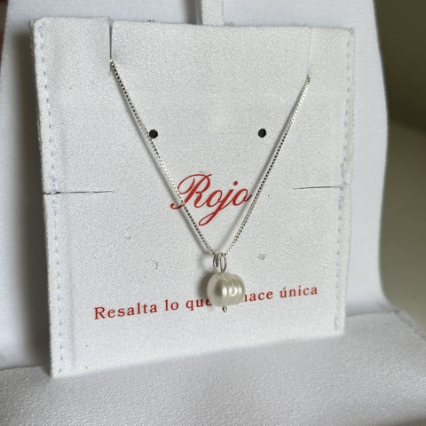 Collar de plata con perla cultivada en un estuche blanco con el logo "Rojo".