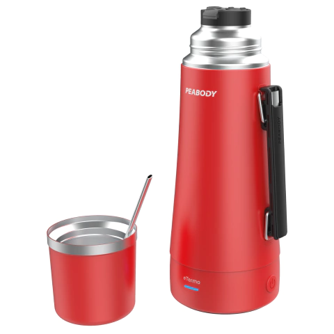 Termo eléctrico Peabody de 1 litro en color rojo, acompañado de un vaso metálico y una cucharita. Ideal para mantener bebidas calientes.