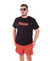 Camiseta preta com a palavra "Pleno" em letras vermelhas, modelo casual, usada por um homem que está de óculos escuros e shorts vermelho.