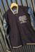 Campera Varsity Negra y Beige con Mangas de Cuero Sintético