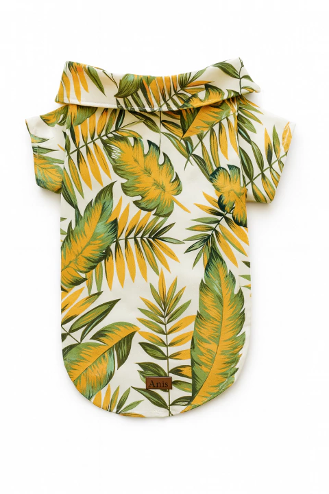 Camisa tropical para perro con estampado de hojas verdes y amarillas sobre fondo blanco