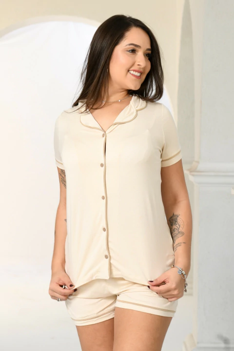 Pijama americano curto bege sem estampa com blusa de botões e shorts, modelo feminino.