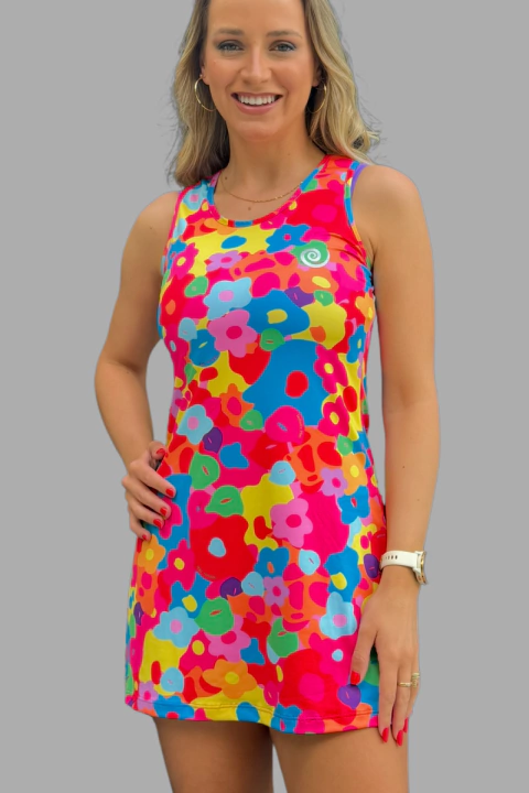 Mulher sorrindo usando vestido Nadine com estampa floral colorida vibrante, sem mangas